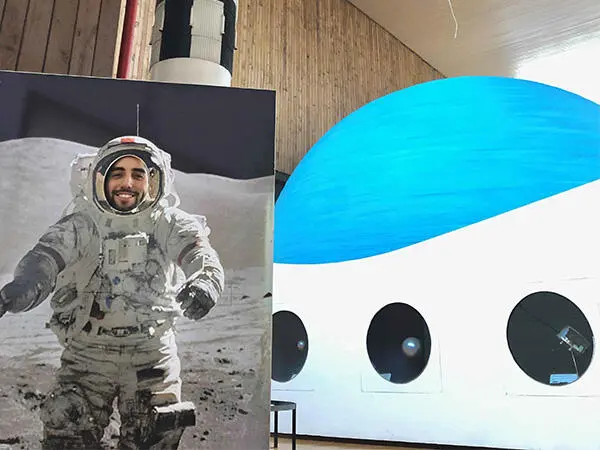 Eric placing his face in an astronaut-themed photo cutout panel